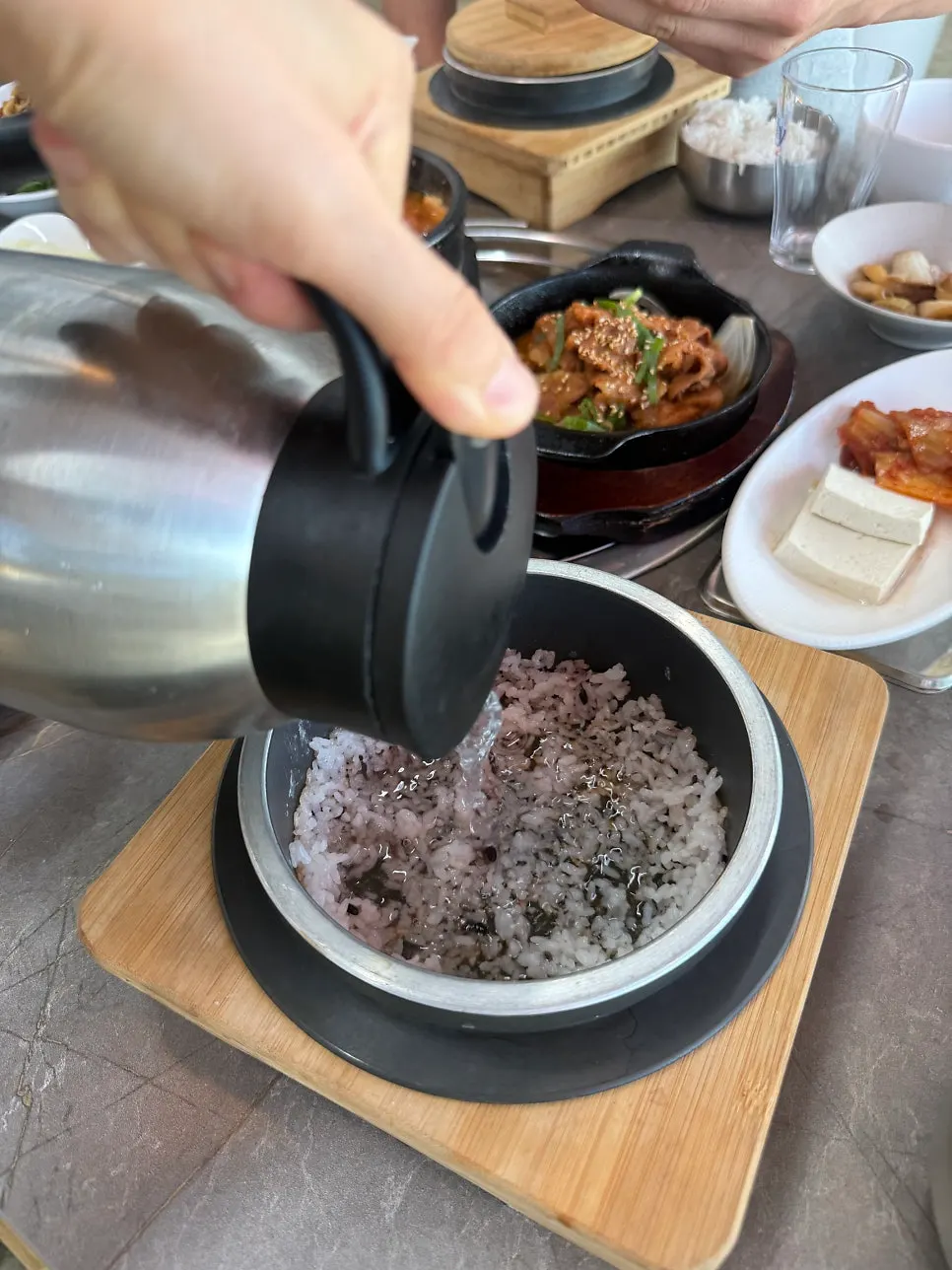 Bubbling stew in a ttukbaegi with side dishes