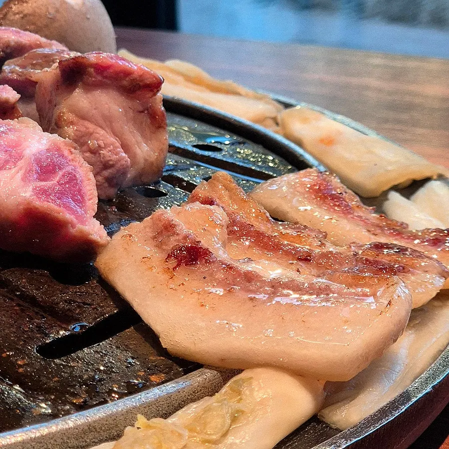 A piece of black pork topped with grilled aged kimchi
