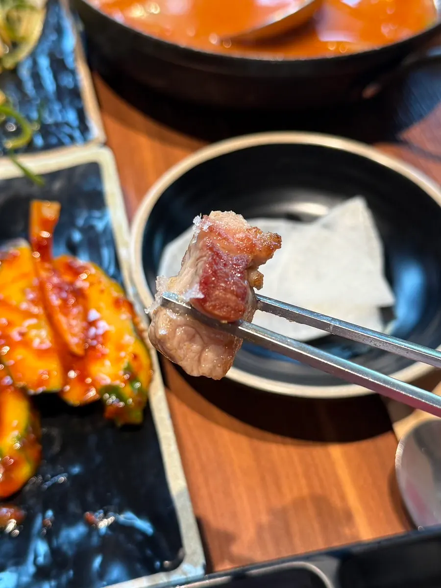 Neatly arranged black pork meal with accompaniments