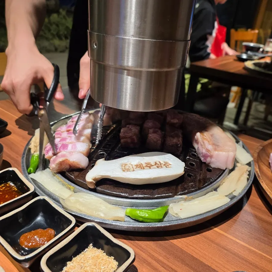 불판 위에서 구워지는 두꺼운 흑돼지