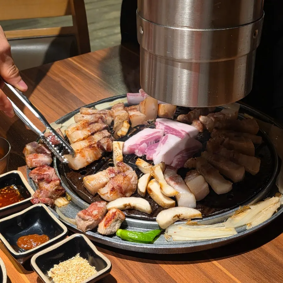 제주삼춘 흑돼지 한 점 집어든 모습