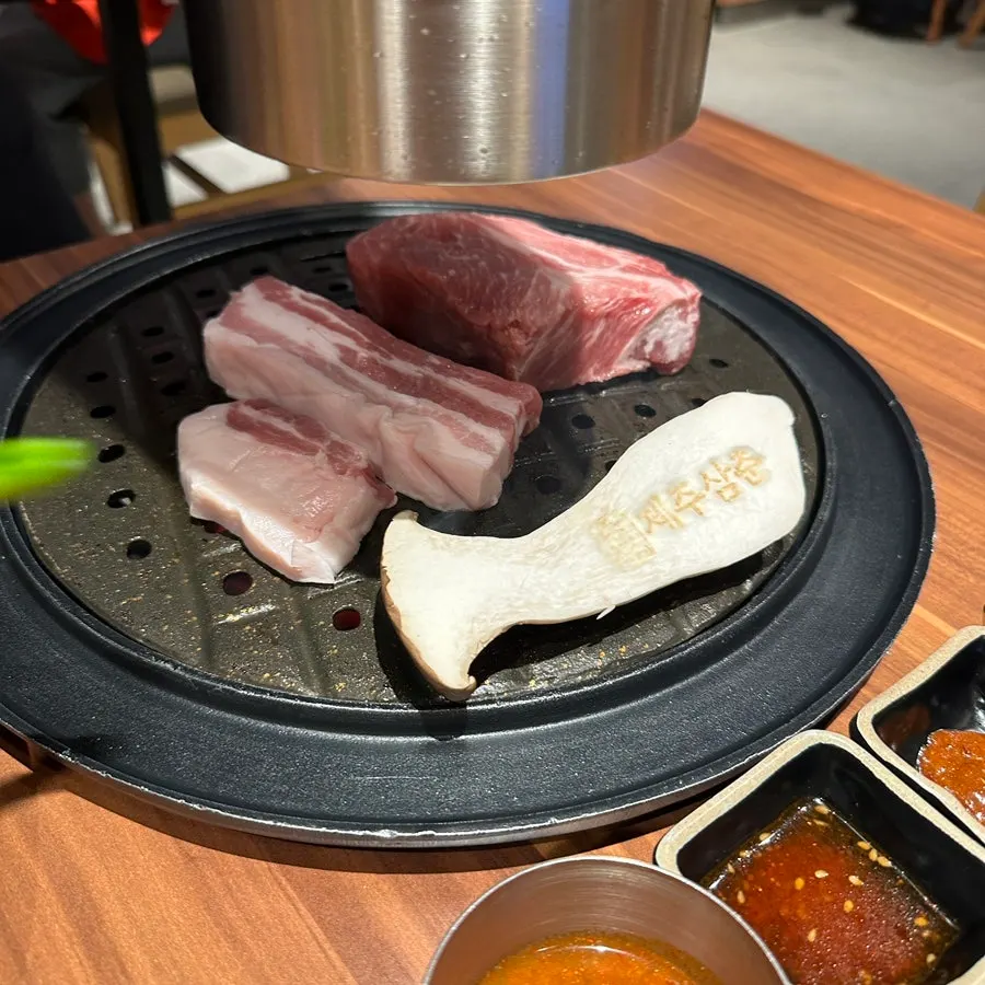 숯불 위에서 구워지는 두툼한 흑돼지 목살
