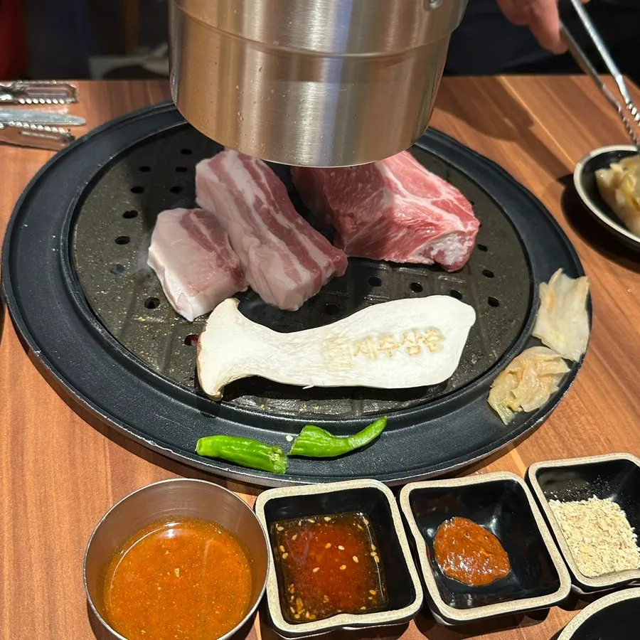 불판 위 노릇하게 익어가는 흑돼지 구이