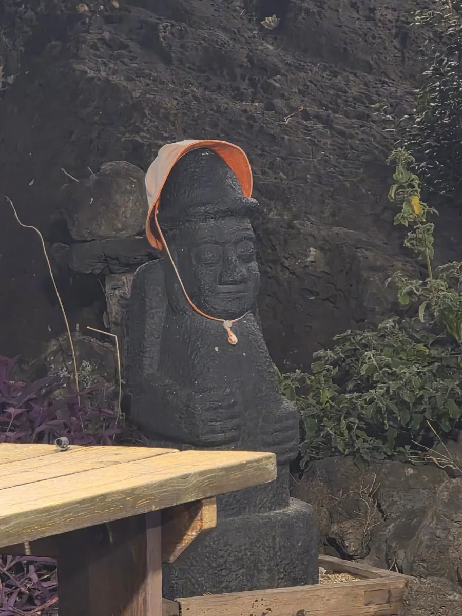 Softly lit outdoor space with a dol hareubang statue