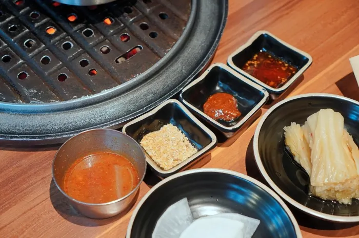 A bite of black pork wrapped with grilled aged kimchi