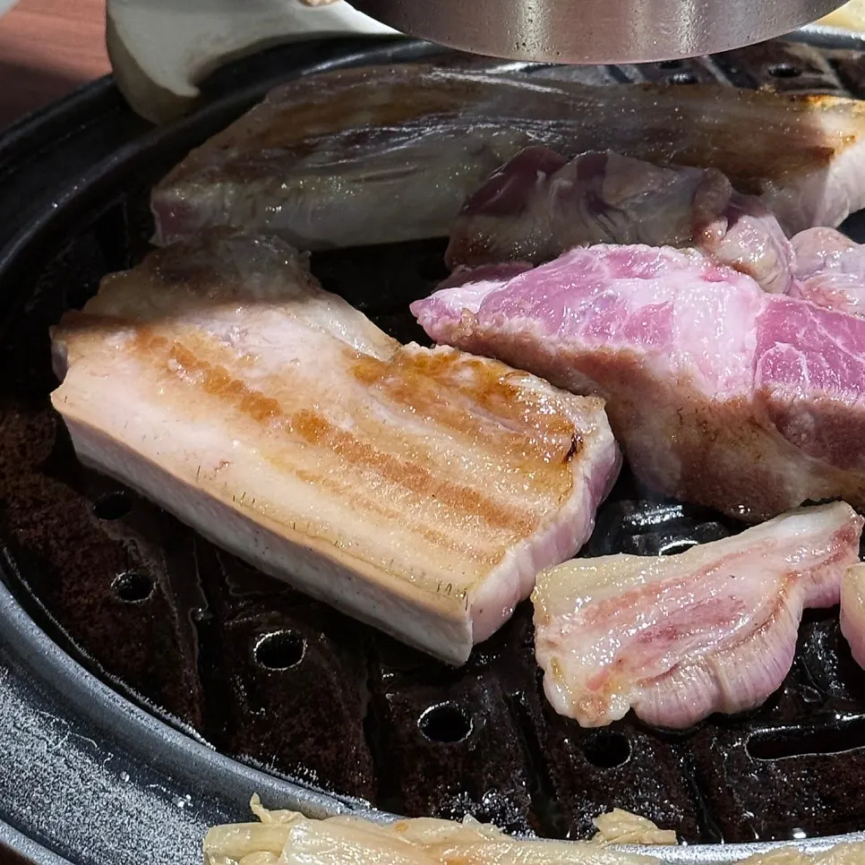 Grill loaded with vegetables and kimchi alongside black pork