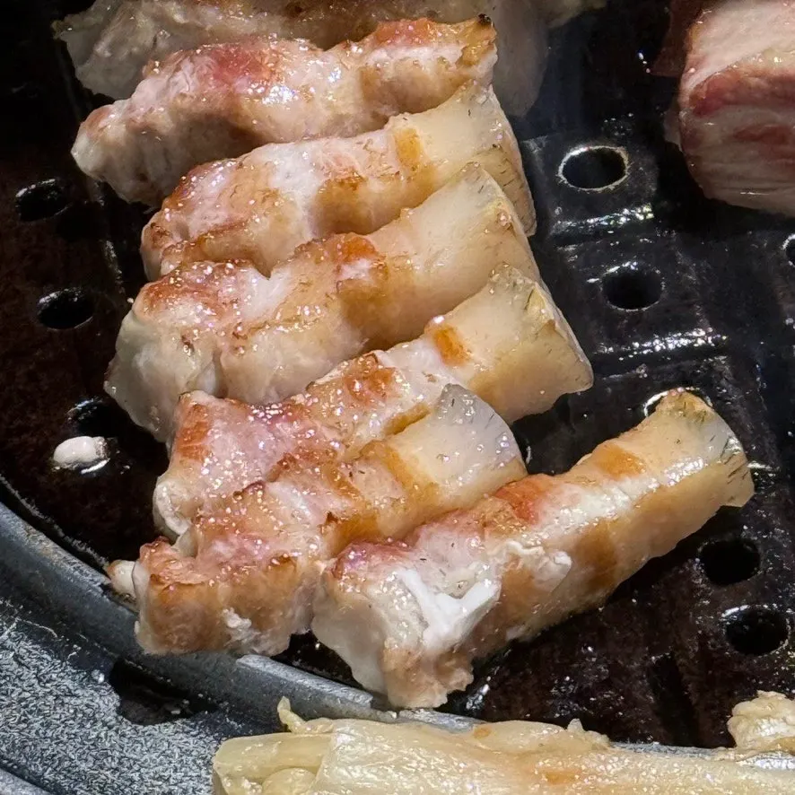 Thick black pork belly grilled by staff