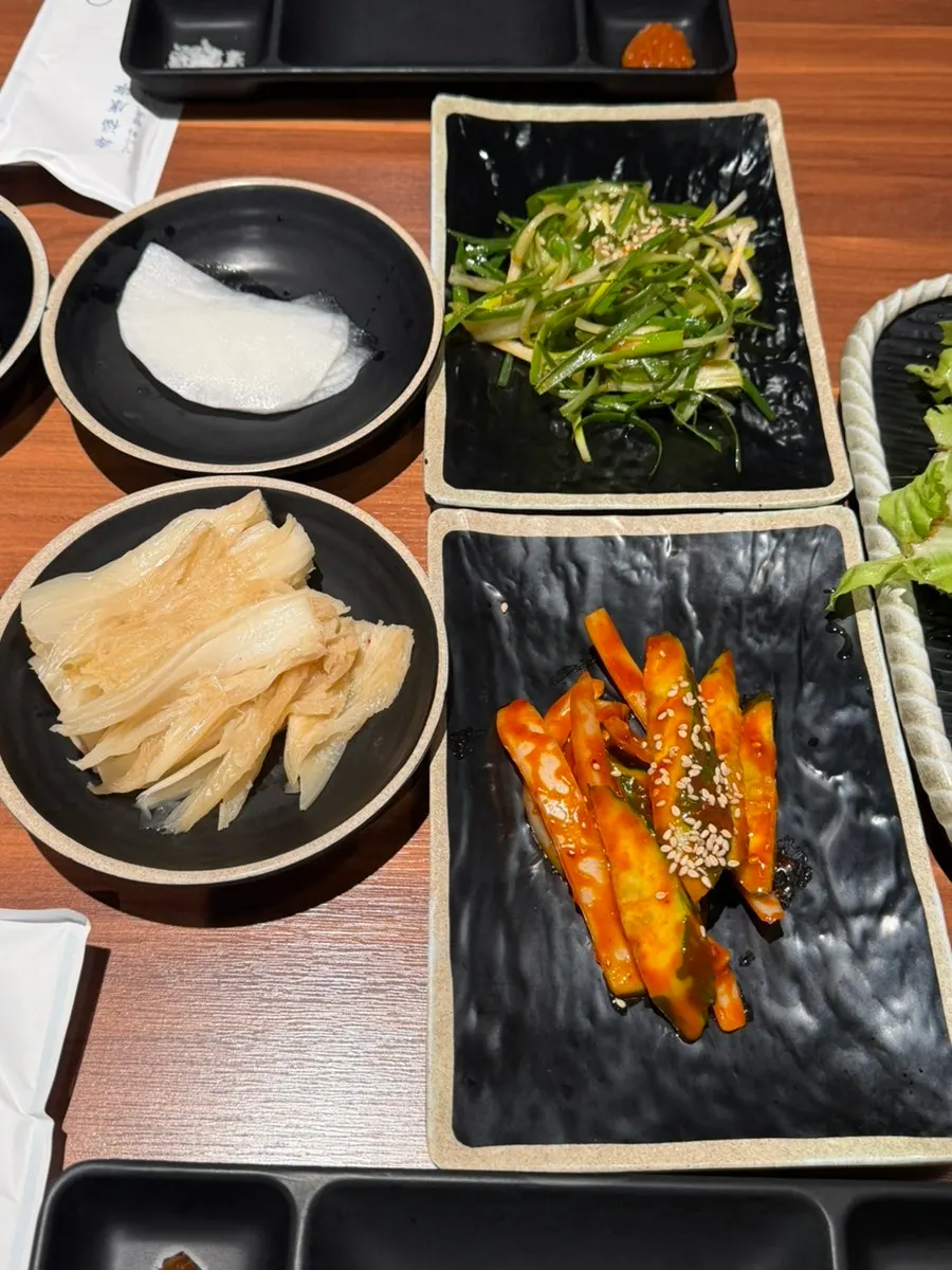 백김치와 쌈채소가 놓인 밑반찬 구성