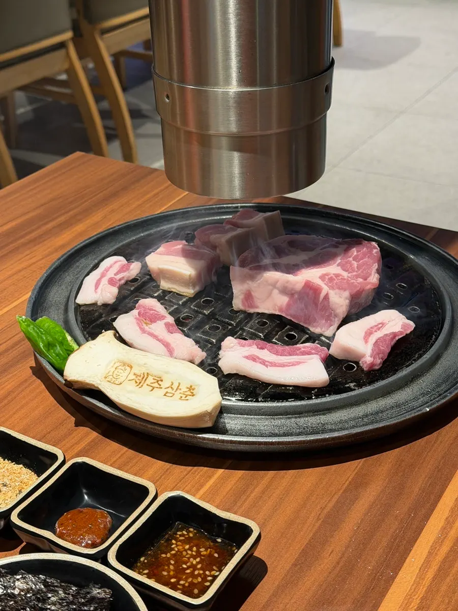 직원이 불판에 흑돼지를 굽는 장면