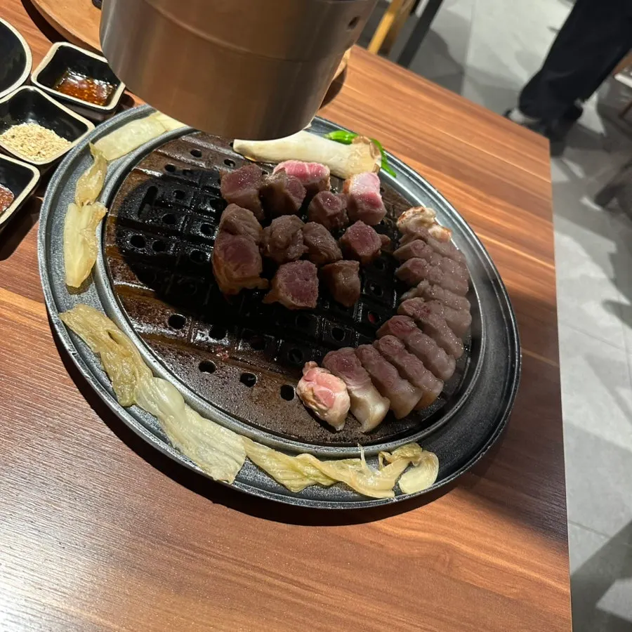 Staff member finishing the grilling of the black pork