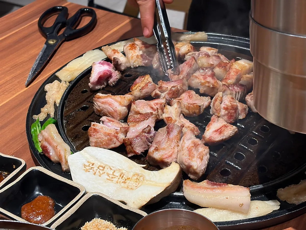 Staff grilling black pork belly and neck