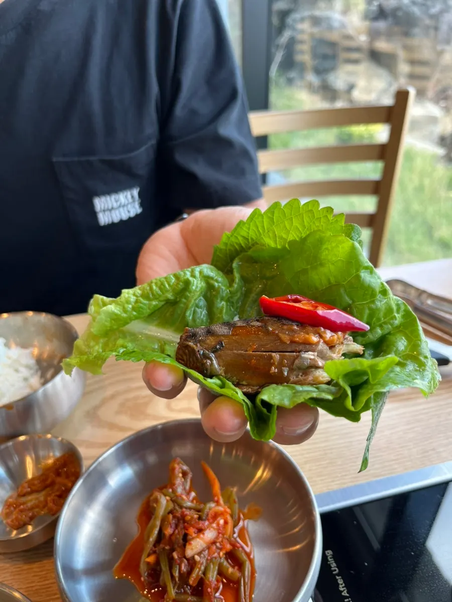 Rice and mackerel flesh wrapped in a vegetable leaf