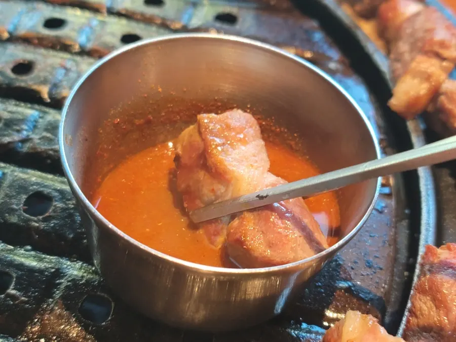 Black pork dipped in myeoljeot bubbling on the grill