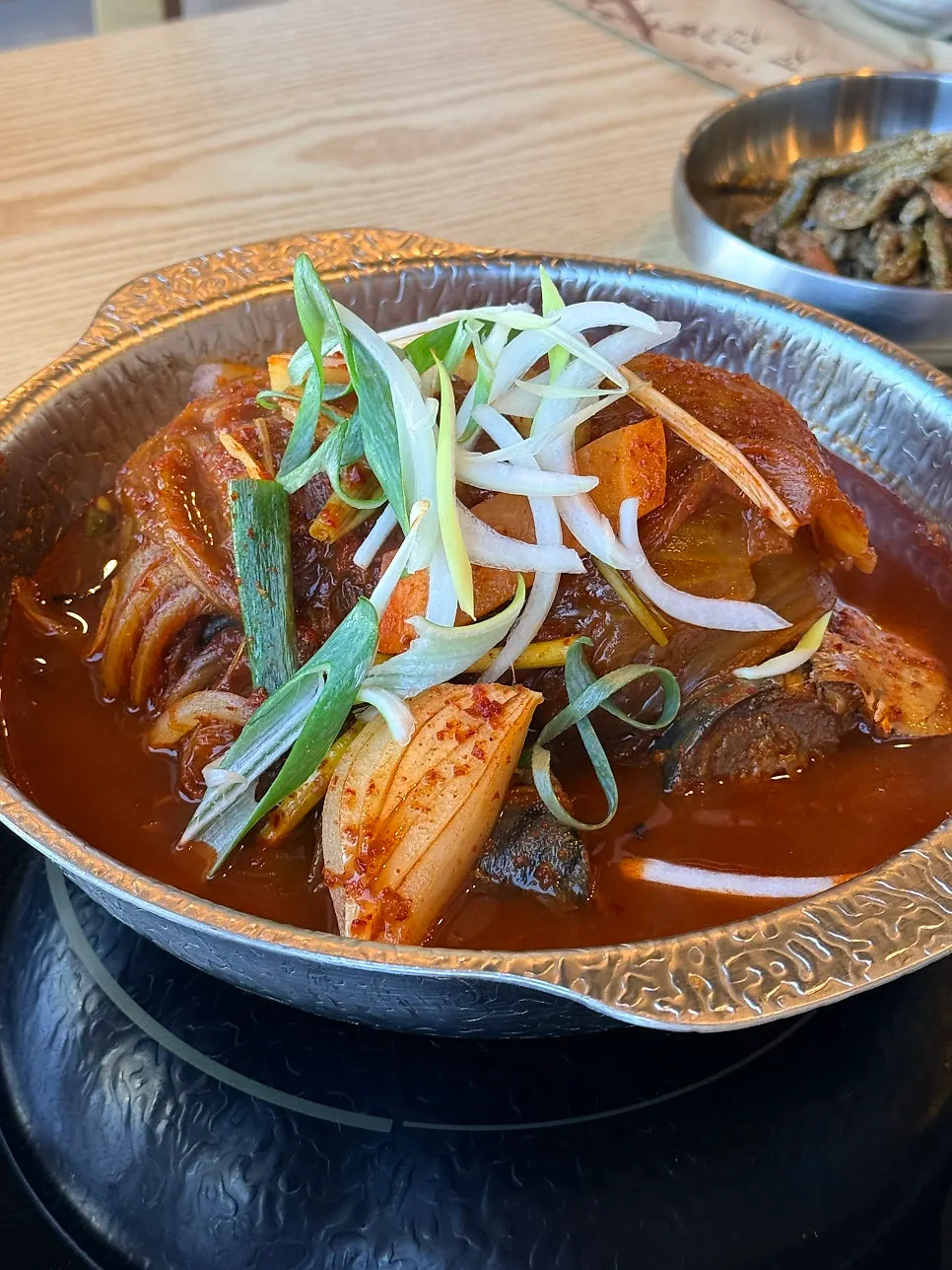 Close-up of braised mackerel with aged kimchi underneath