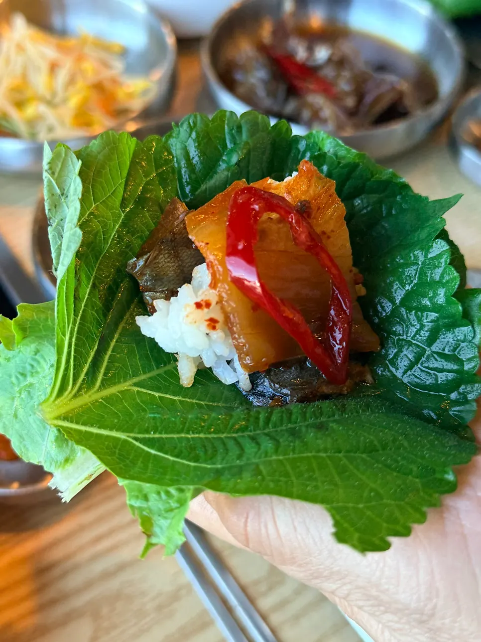 A bite of mackerel ssambap wrapped and ready to eat