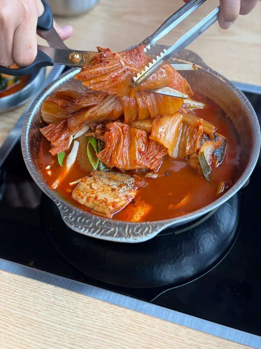 Pot of mackerel kimchi stew with a whole piece of aged kimchi