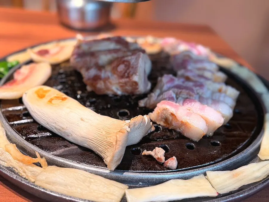 Lidded dish holding grapevine-smoked pork