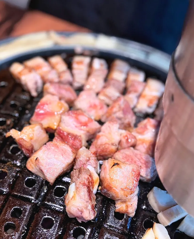 Staff member grilling black pork tableside