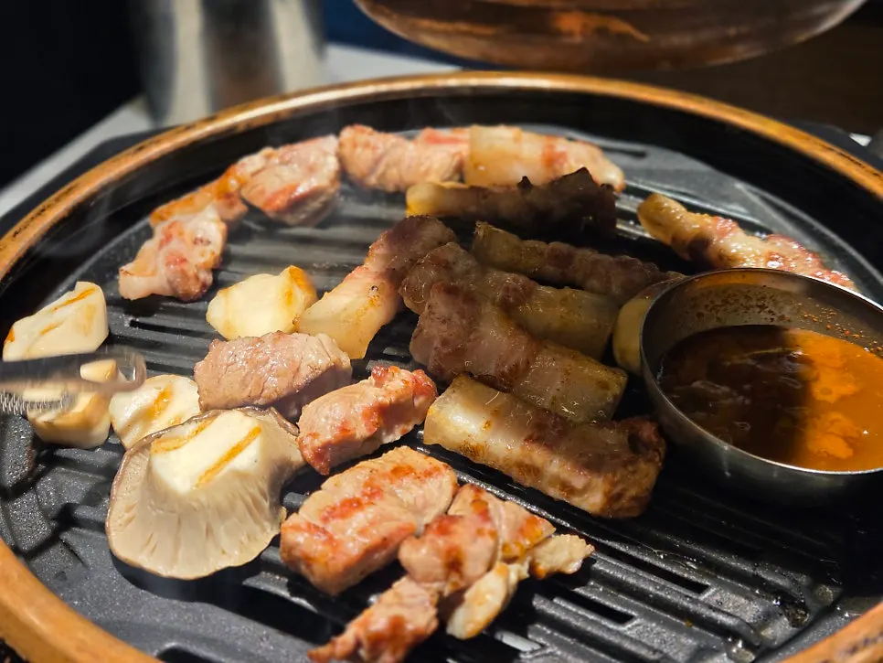 직원이 구워주는 고기와 불판 위 멜젓
