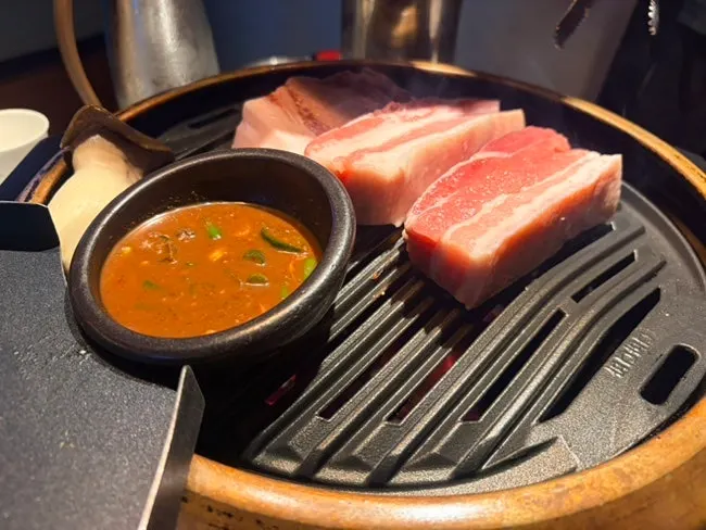 Pork belly and pork neck finishing on the grill