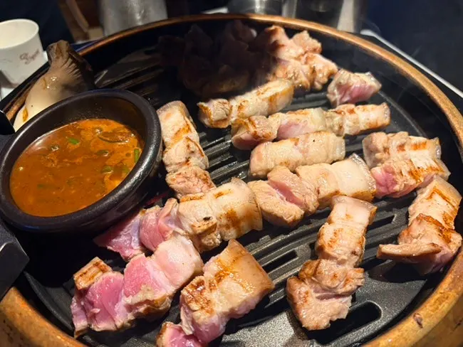 A piece of pork belly with wasabi and salted shrimp