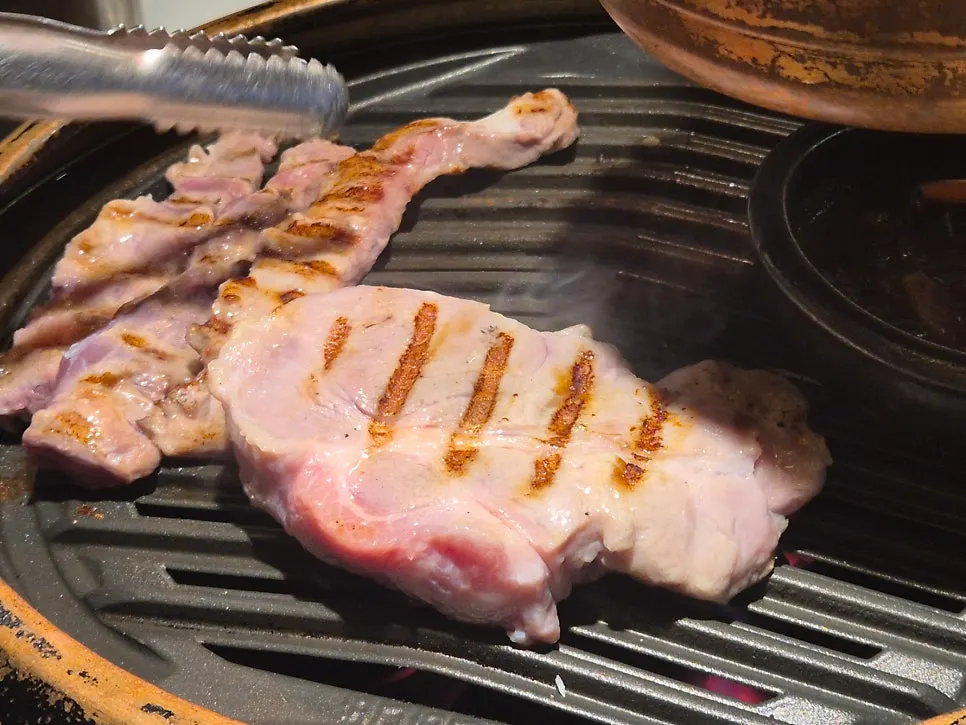 버섯과 함께 담긴 두툼한 숙성 돼지고기