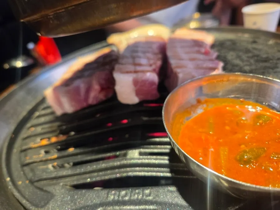 Pork belly being placed on the grill