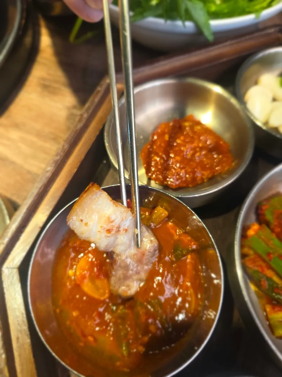 Picking up a piece of grilled pork belly