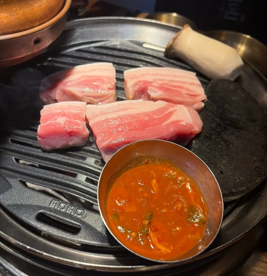 Thick aged pork belly placed on the grill