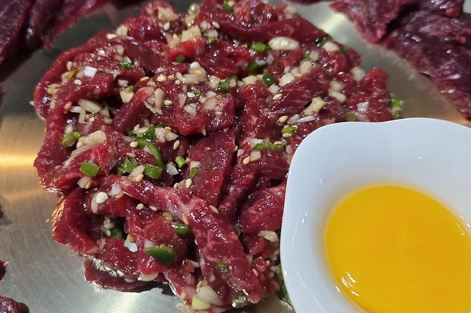 Yukhoe topped with an egg yolk in the center