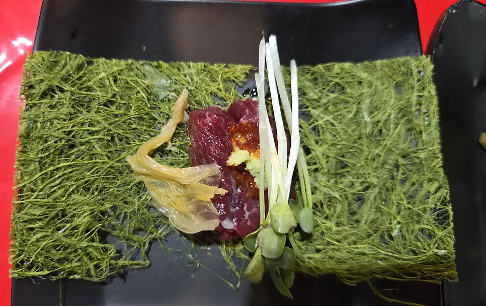 A single piece of mungtigi picked up with chopsticks