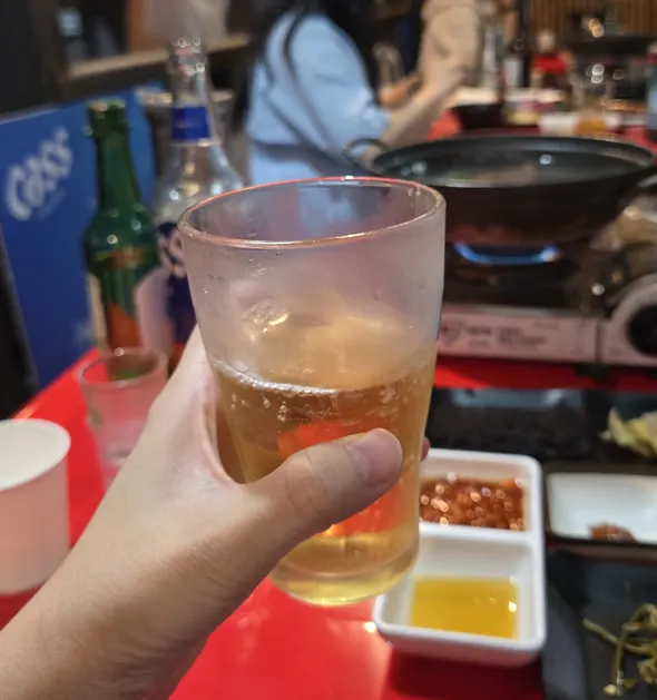 Outdoor tent table with raw beef and a drink