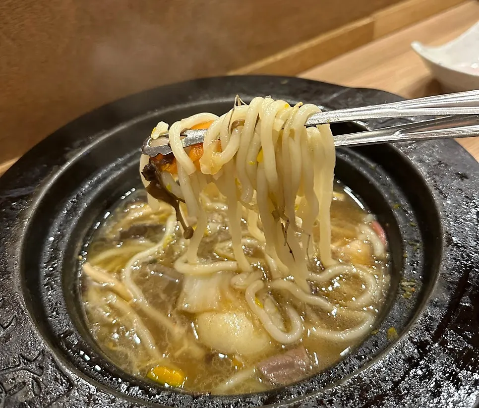 Udon noodles added to the enriched broth