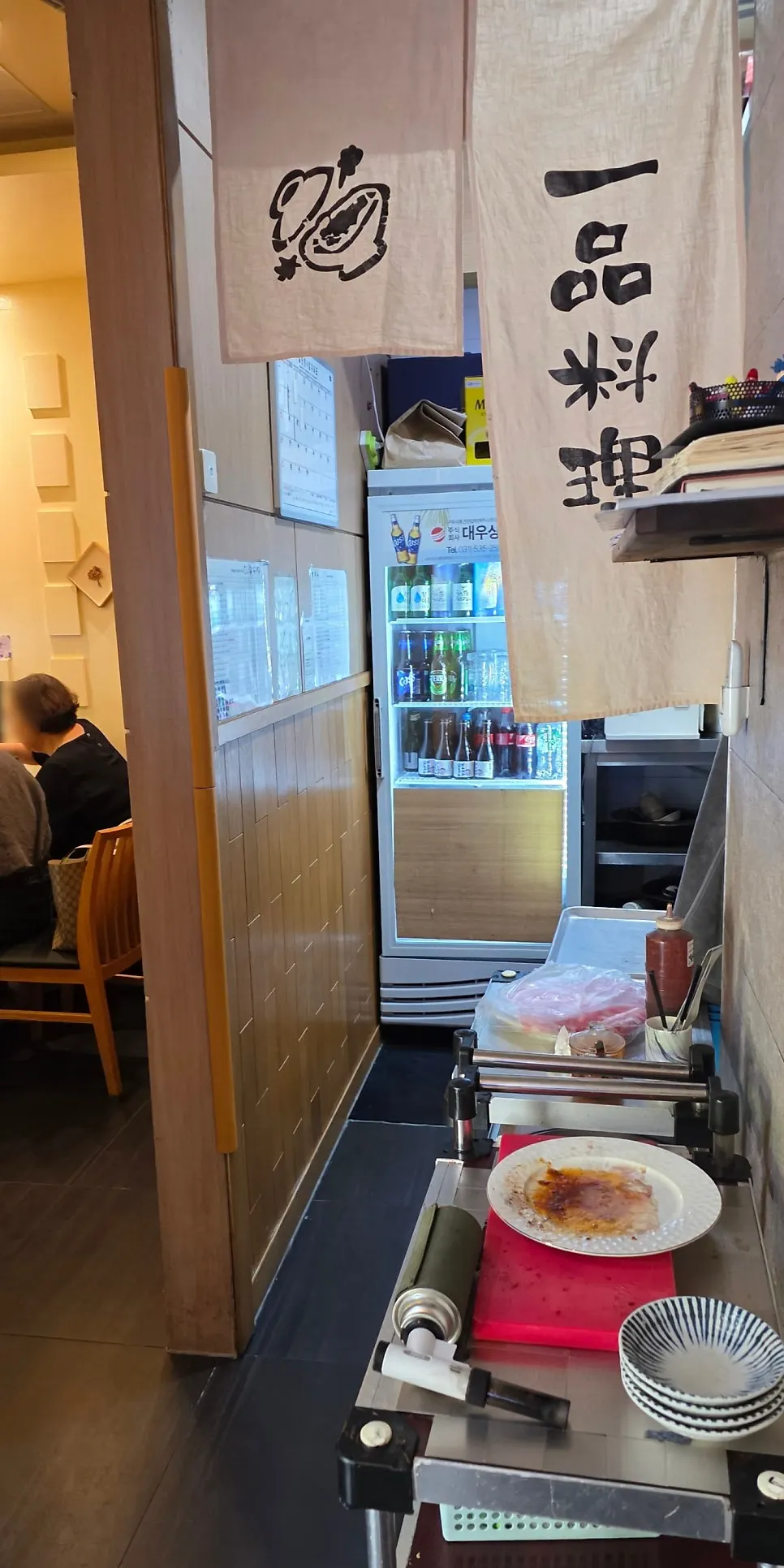 Sake bottles displayed on the shelf above the bar