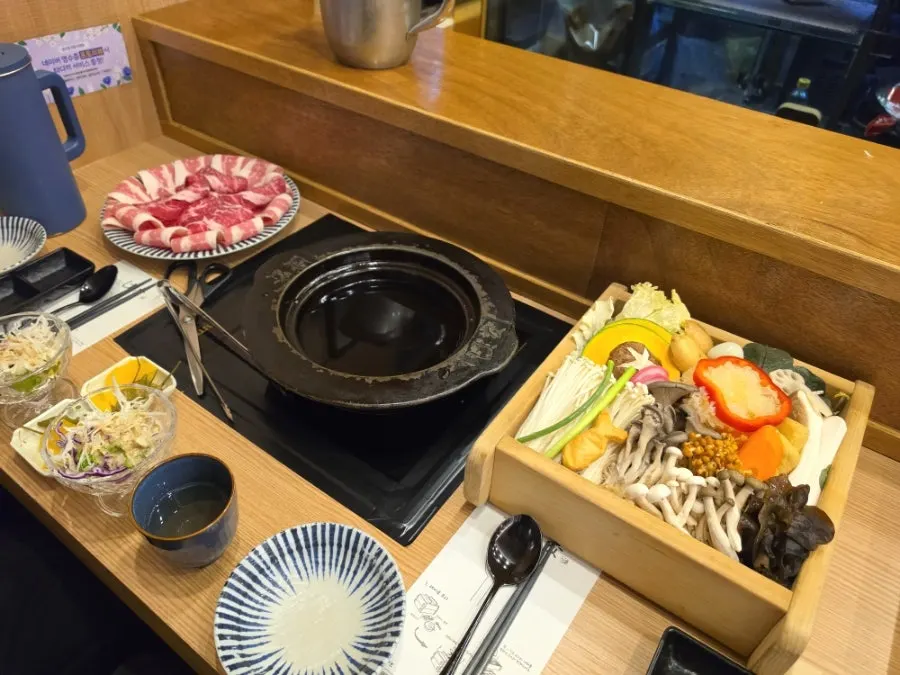 Basic dinner shabu-shabu setup with cast-iron pot, meat, and vegetables
