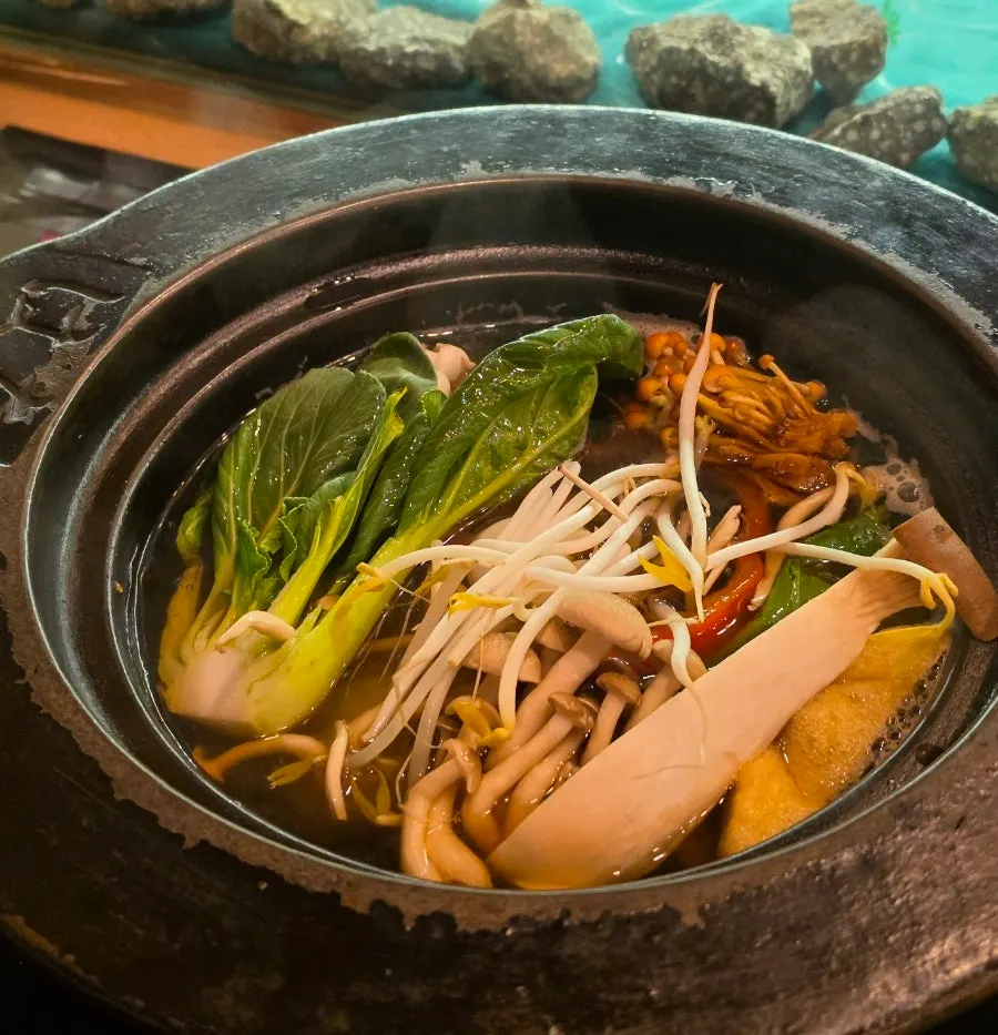 Plate of shabu-shabu vegetables with bok choy, bean sprouts, and mushrooms