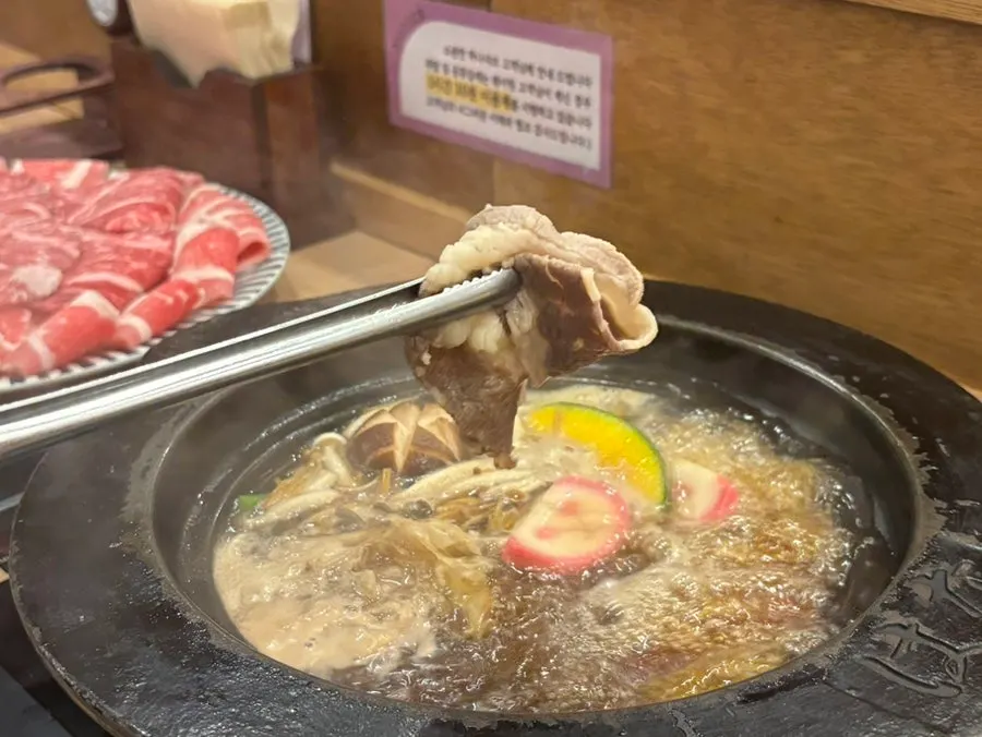 소스에 찍어 먹기 직전의 샤브샤브 고기 한 점