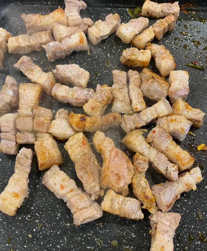 돌판에 오겹살과 나물 김치를 굽는 모습