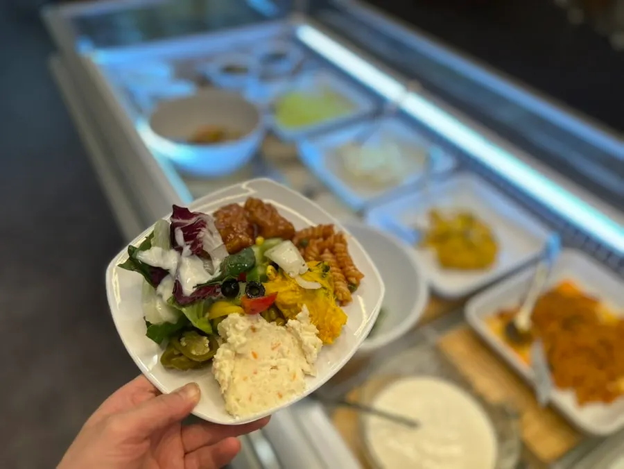 A plate loaded with a variety of salad bar items