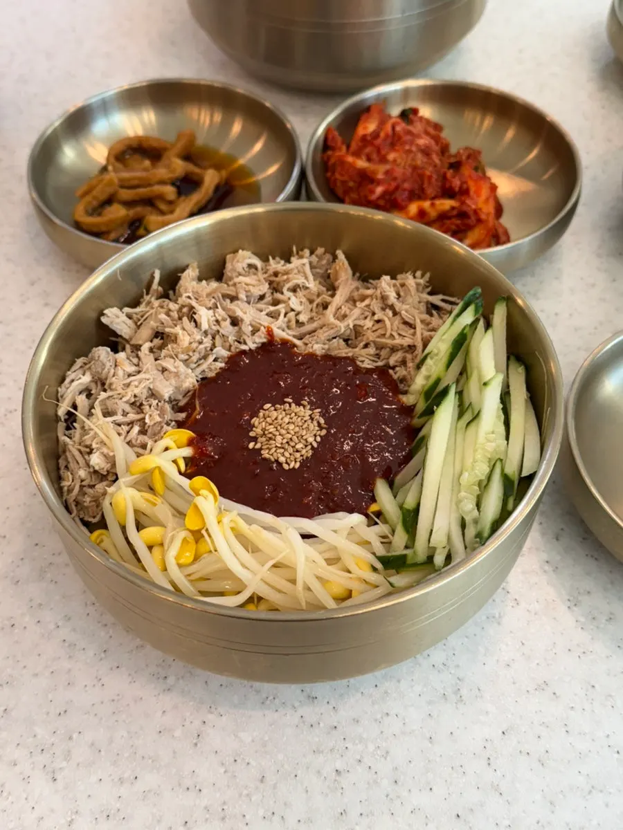 Two bowls of noodles served in brass yugi bowls