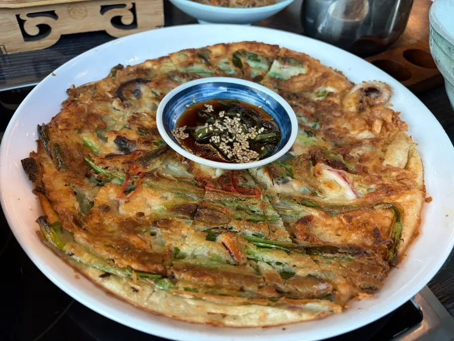 Golden-brown seafood pancake served at the table