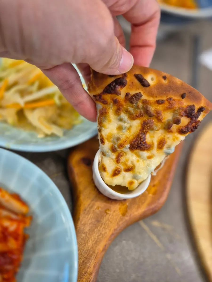 A slice of gorgonzola pizza with honey drizzle