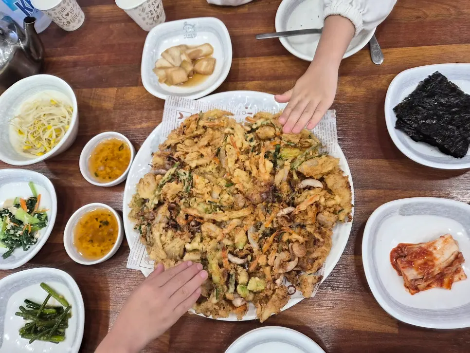 Kids' hands placed on the seafood pancake plate
