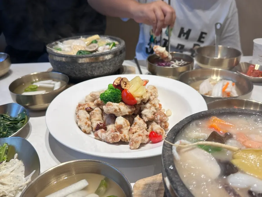Table spread with the hot bubbling abalone rice soup