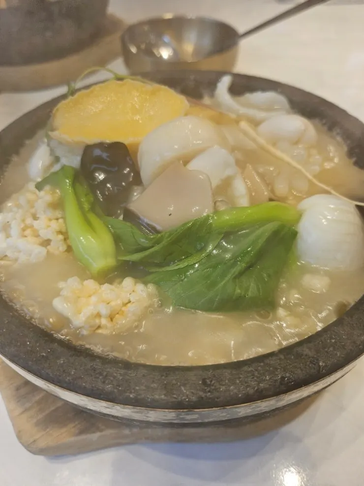 Abalone rice soup arriving bubbling in a stone pot