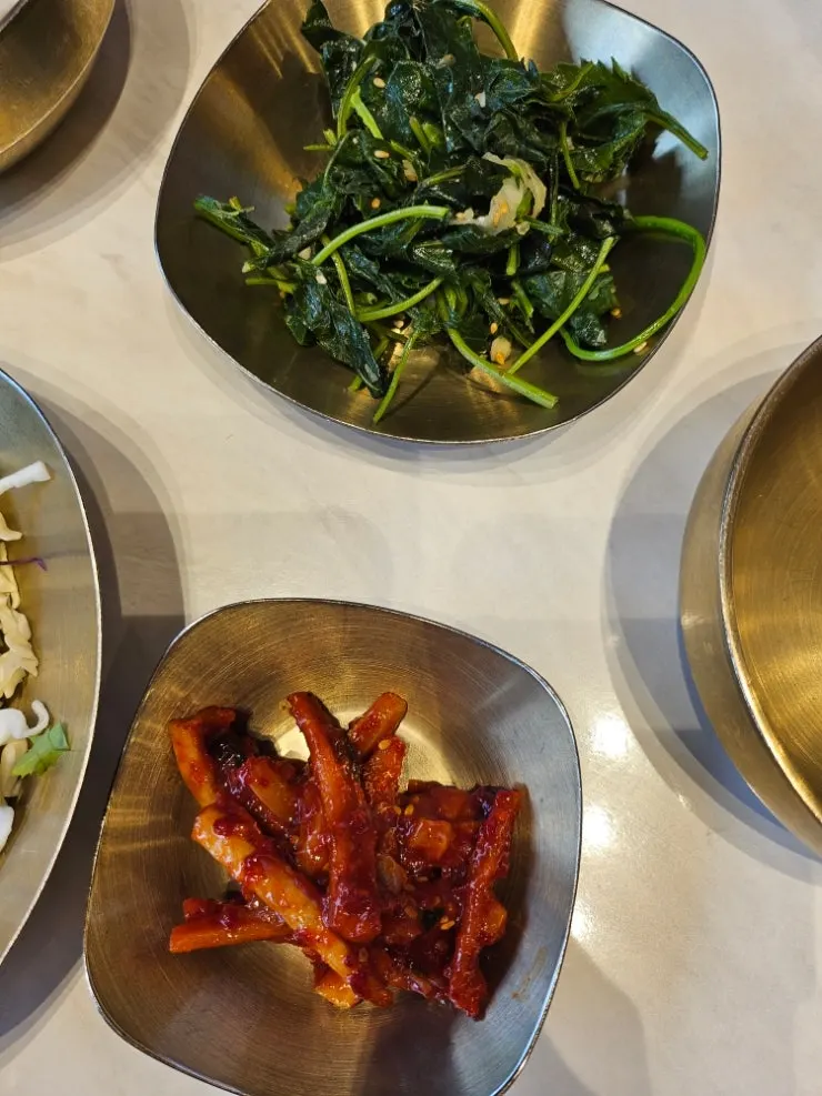 Table setting with chive salad and radish kimchi