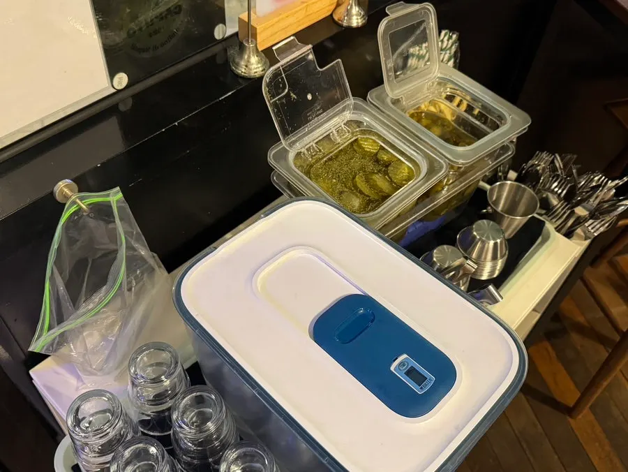 Self-serve bar with water, cutlery, pickles and jalapeños