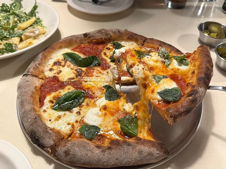 A slice of Ricotta Honey Pepperoni pizza loaded with toppings
