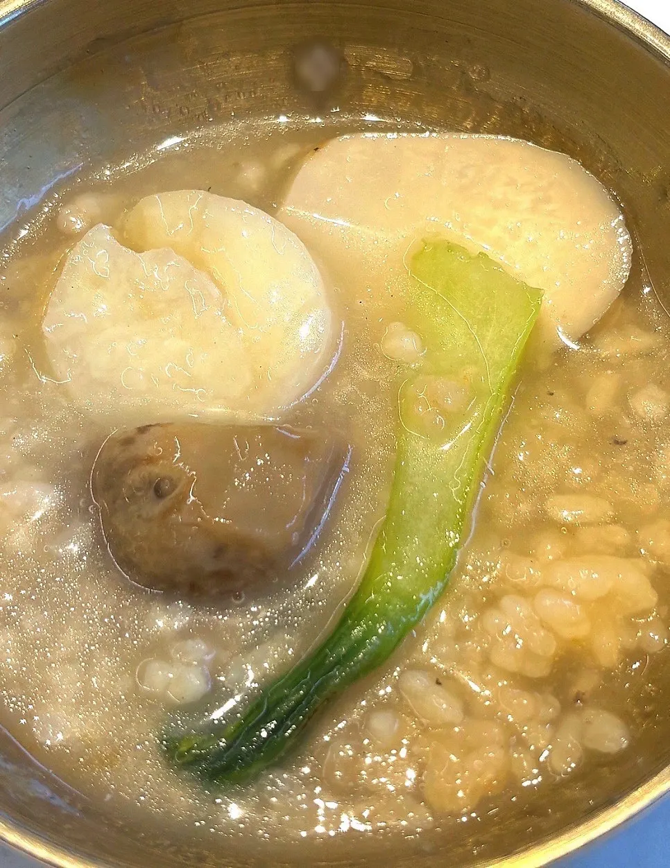 A spoonful of nurungjitang with scallops and shrimp