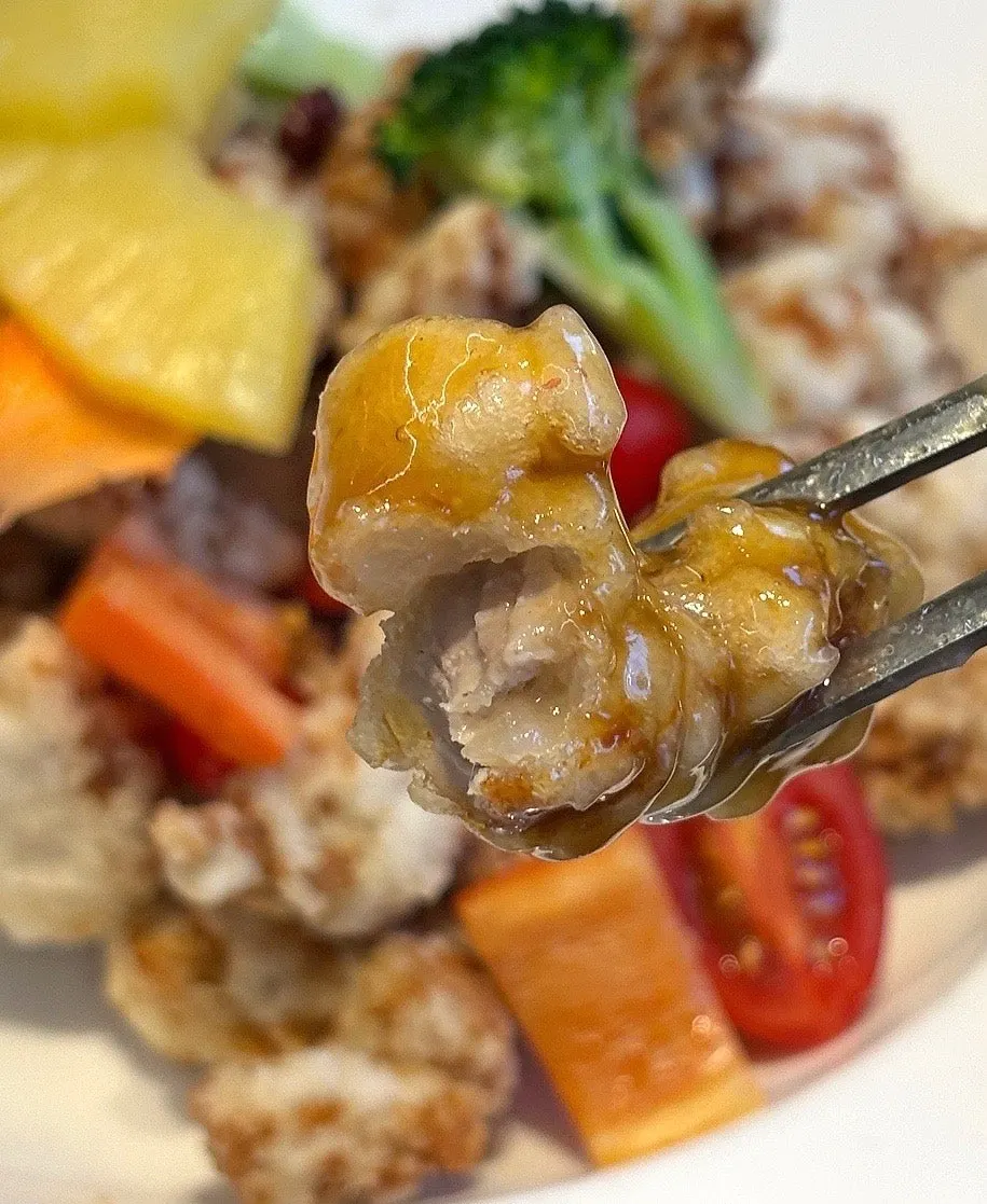 A piece of sticky rice tangsuyuk dipped in sauce